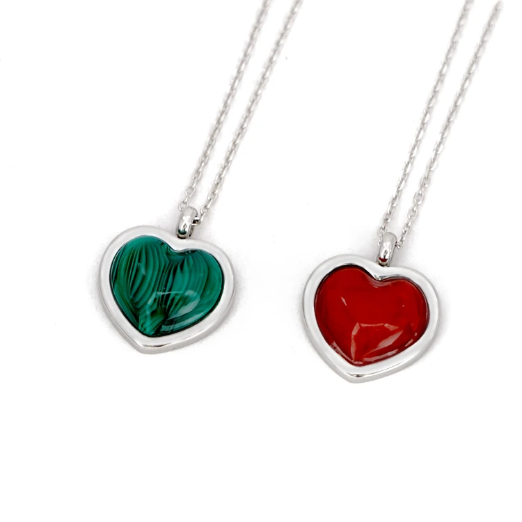 Two heart-shaped pendants with green and red inlays