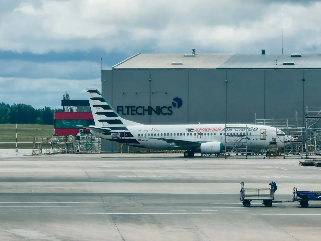 Cargo aircraft parked on an airport apron near a hangar