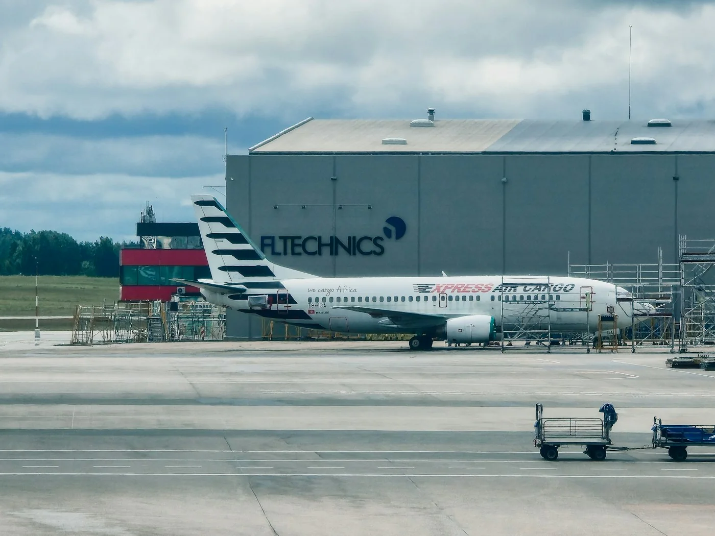 Cargo aircraft parked on an airport apron near a hangar