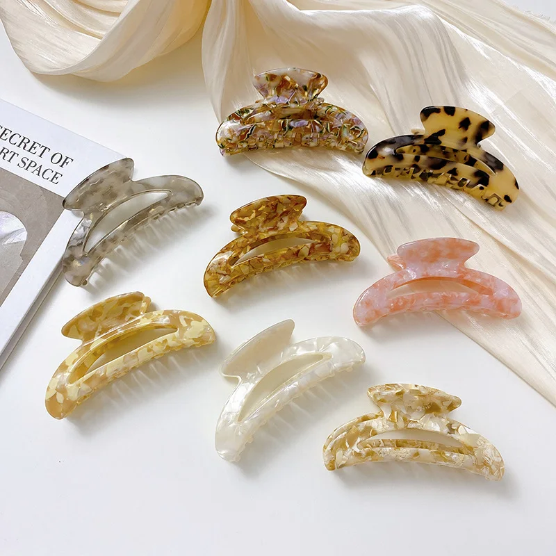 Custom curved hair claw clips displayed in assorted acetate colors and patterns