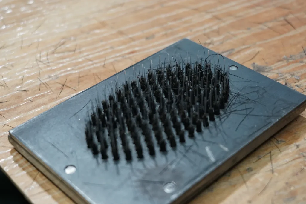 Bristles, pins and brush cushion used as fittings in an assembled hairbrush