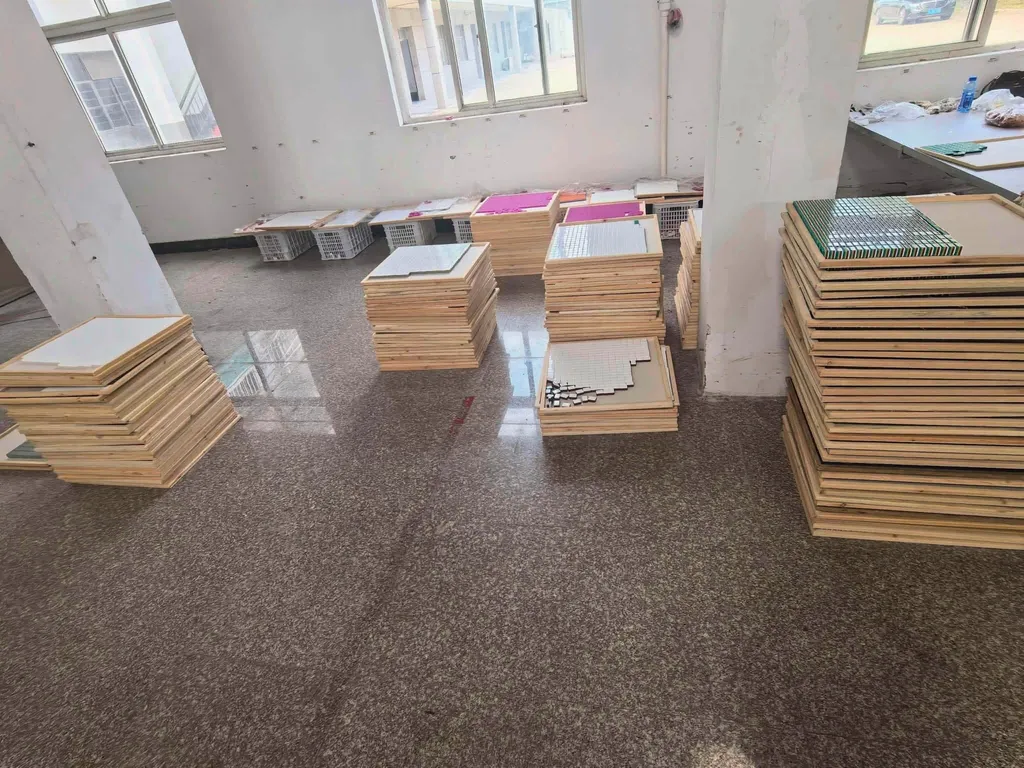 Stacks of wooden trays holding rows of mahjong tiles in a workshop
