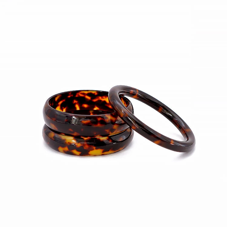 Tortoiseshell-pattern bangles arranged on a white background